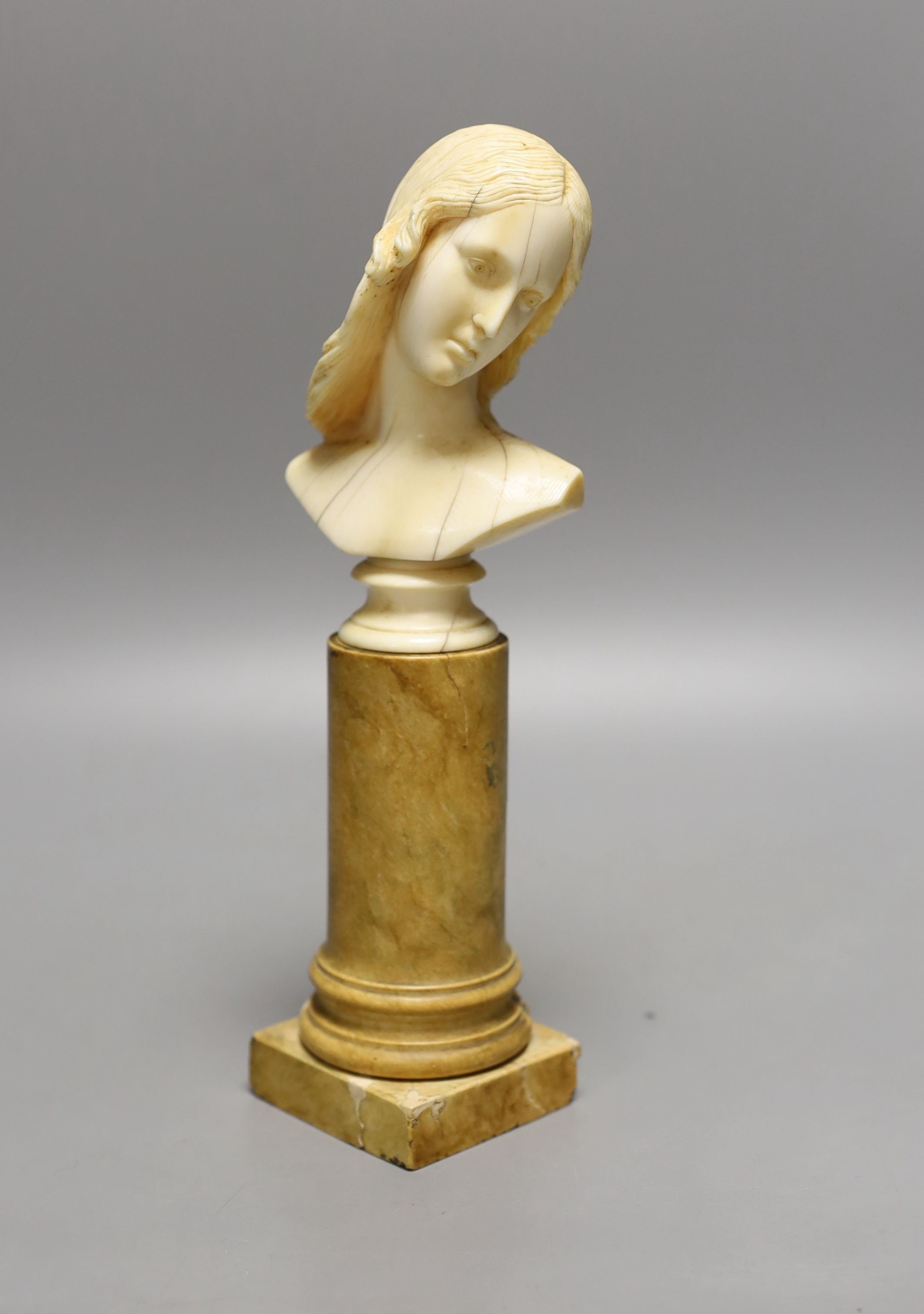 An 18th/19th century grand tour ivory bust of a lady on a Siena marble pedestal, 24cm